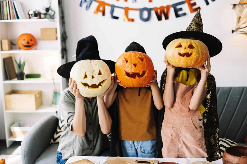 children dressed up holding jack o lanterns